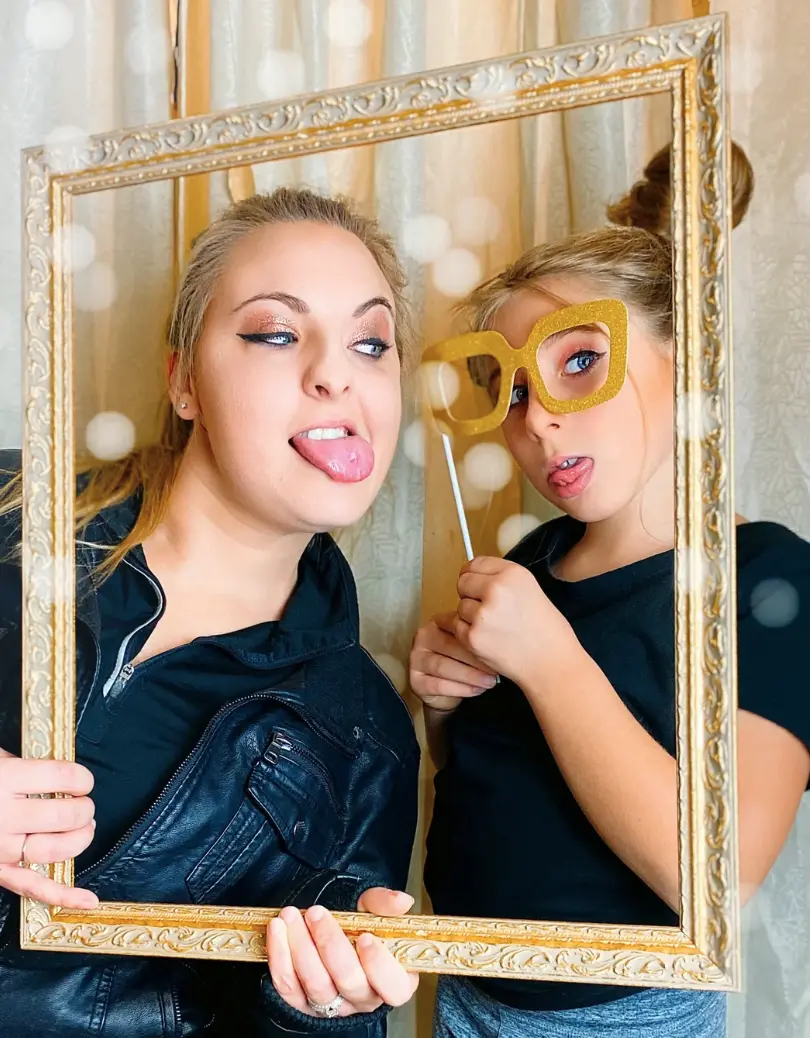 Mutter und Tochter mit goldenem Bilderrahmen vor der Fotobox